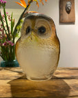 Close-up view of Maleras Small Crystal Brown Owl Swedish Glass Art, highlighting its delicate crystal texture and expressive eyes, featured amidst an elegant floral arrangement, exclusively at Spacio India.