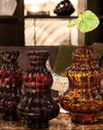 Three decorative crystal vases on a table with a blurred indoor background