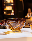 Mario Cioni Crystal Baboda Passion Suspended Bowl on a table with other amber bowls available at Spacio India for luxury home decor accessories collection of Bowls & Centerpieces.