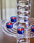 Crystal vase styled with blue votive holders