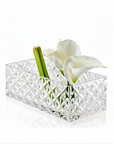 Clear crystal centre piece with white flowers and green stems on a white background