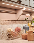 Decorative vases and bowls on a kitchen counter with marble backsplash