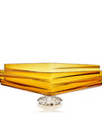 Amber-colored square crystal bowl with a clear base on a white background