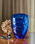 Blue crystal vase on a wooden surface with decorative elements