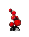 Red crystal sculpture on a black base against a white background