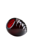 Crystal object with red interior and black exterior on a white background
