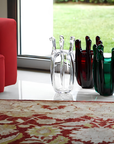 Mario Cioni Crystal Green Liquid Mood Vase by Tondo Doni with Red & Clear Vases on floor beside Sofa set in interior available at Spacio India for luxury home decor accessories collection of decorative Vases.