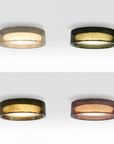 Four circular flush-mount ceiling lights each with a different metallic glass finish: textured gold, dark gold, polished gold, and copper-toned gold, all shown illuminated against a light gray background.