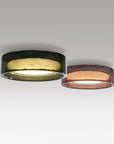 Two circular ceiling lights with different finishes on a gray background