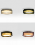 Four circular flush-mount ceiling light fixtures shown in a 2x2 grid, each with a different outer rim finish: textured silver, glossy black, dark bronze, and copper. The fixtures are shown illuminated against a clean white background.