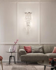 Living room with a gray sofa, red pillows, and a crystal wall light.