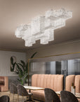 Modern chandelier hanging in a stylish interior setting with furniture and decor.