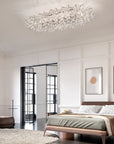 Modern bedroom with a crystal chandelier from Masiero, bed, and wall art.