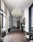 Modern interior with a chandelier, bookshelf, and seating area.