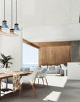 Sea side outdoor dining and sofa set along with potted green plants and colourful pendant lights above the dining table.