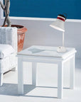 White side table with a rechargeable table lamp from Masiero and plant in a minimalistic room.