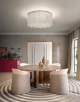 Modern dining room with a round table and chairs, featuring the Cristalle chandelier from Masiero, available at Spacio retail stores in India.