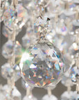 Close-up of a crystal chandelier with clear and multicolored prisms.