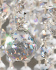 Close-up of a crystal chandelier with clear and multicolored prisms.