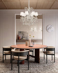 Dining room with a round table and chairs, featuring a crystal chandelier from Masiero.
