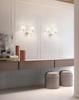 Modern interior with a long vanity table, stools, and wall-mounted lights crystal lights from Masiero, available at Spacio in India.