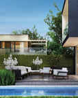 Modern house exterior with pool, garden, and outdoor furniture and table outdoor chandeliers.