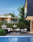Modern house exterior with pool, garden, and outdoor furniture and table outdoor chandeliers.