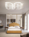 A grand ceiling crystal chandelier from Masiero available at Spacio, in a modern bedroom setting