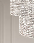 Crystal chandelier hanging from a ceiling in a room with a blurred background