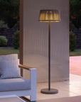 Modern outdoor indoor solar floor lamp next to a sofa in a garden setting by Les Jardins available at Spacio retail stores in Mumbai & Kolkata.