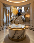 Luxurious interior with a decorative sculpture on a marble pedestal in a grand hallway.
