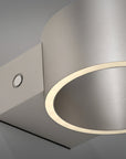 Modern wall-mounted rechargeable light fixture with a metallic finish on a gray background