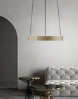 Modern interior with a gray tufted sofa and pendant kinetic light against a neutral wall.