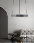 Modern interior with a gray tufted sofa and kinetic chandelier.