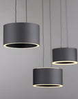 Three black pendant lights against a gray background