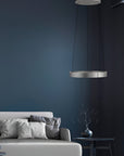 Modern living room with a dark blue wall, gray sofa, and pendant kinetic light.
