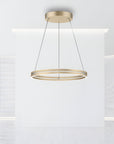 Gold pendant kinetic light fixture hanging in a modern interior setting