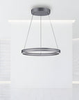 Modern pendant kinetic light fixture hanging from the ceiling in a minimalistic room.