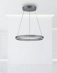 Modern pendant kinetic light fixture hanging from the ceiling in a minimalistic room.