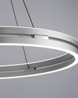 Circular pendant kinetic light fixture on a gray background