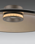 Close-up of a modern ceiling light fixture with metallic finish on a neutral background