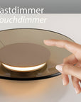 Hand touching a touchdimmer switch on a light fixture with 'Tastdimmer Touchdimmer' text.