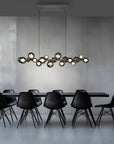 Modern dining room with black chairs and a long, stylish kinetic chandelier.