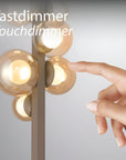 Hand touching a touchdimmer switch on a modern light fixture with 'Tastdimmer Touchdimmer' text.