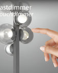 Hand touching a touchdimmer switch on a light fixture with 'Tastdimmer Touchdimmer' text.