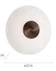 Round white object with bronze center and measurements on a white background