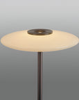 Floor lamp with a round white shade and metallic base on a gray background