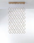 Decorative ceiling light fixture with wavy design on a white background