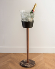 Decorative vase with a bottle on a stand against a white wall