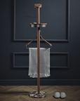 Wooden coat rack with a towel against a dark wall